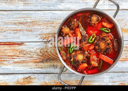 Rabo de Toro ou ragoût de queue de boeuf aux légumes, le thym, le vin rouge et le piment jalapeno morceaux en casserole sur la vieille table en bois foncé, recette authentique, Banque D'Images