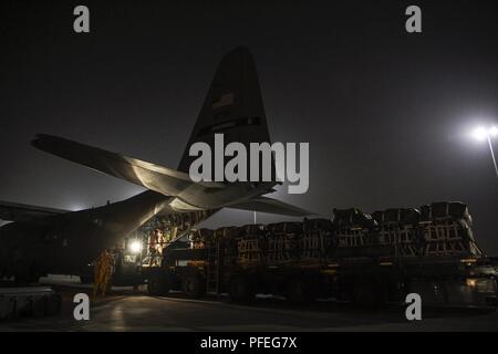 Les aviateurs de l'US Air Force affectée à la 8e Escadron expéditionnaire de l'aéromobilité de l'armée américaine et des soldats de la 541e Bataillon de soutien au maintien en puissance de combat, de charger des palettes sur un C-130H Hercules à Al Udeid Air Base, au Qatar, pour un largage de matériel à un endroit tenu secret, à l'appui de la Force opérationnelle combinée du Force-Inherent Résoudre Roundup Opération le 4 juin 2018. Banque D'Images