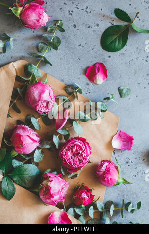 Roses roses dans l'enveloppe sur un fond gris. Le concept d'accueil et de célébration. Soft focus. Banque D'Images