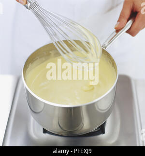 Sabayon d'être mélangés dans une casserole avec un fouet métallique, high angle view Banque D'Images