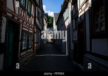 Un faisceau de lumière d'une ruelle étroite fixe à travers une rue de Bacharach, Allemagne. Banque D'Images