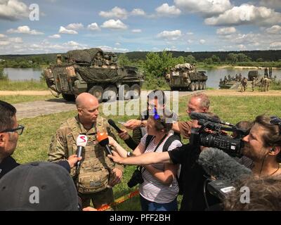 Le brig. Le général Richard R. Coffman, le commandant de l'armée américaine l'Europe de l'élément de commandement de mission et 1ère Division d'infanterie, commandant adjoint de l'adresse aux membres de la composante média lorsque Stryker Cavalry Regiment 2d de combat charger un traversier sur la rivière Nemen lors d'un événement de formation multinationale près de Kulautuva Lithuanie, 13 juin, 2018. L'événement, une partie de la grève 18 Sabre de l'exercice, les éléments du régiment de cavalerie 2d qui traversent la rivière Nemen via ferries fournis par les Britanniques et les armées allemandes, et coordonné par l'armée lituanienne. Grève de sabre est une multinationale annuelle ex Banque D'Images