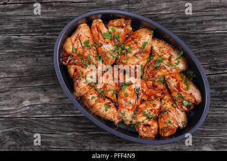 Ailes de poulet crues marinées au miel, sauce soja, le poivre de cayenne et les épices dans un plat ovale, recette chinoise, vue d'en haut Banque D'Images