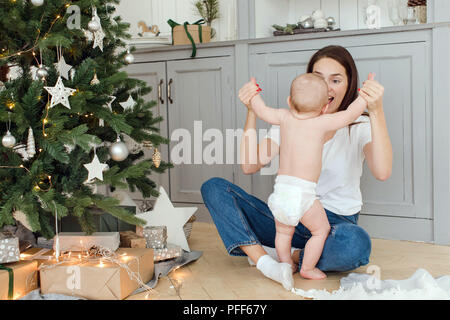 Mère jouer avec bébé near Christmas Tree