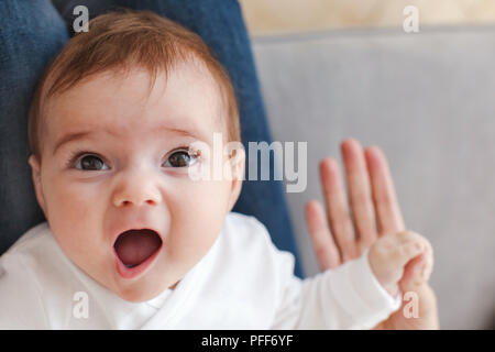 Surpris baby holding mère part Banque D'Images