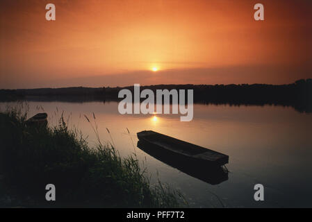 France, Loire Valley, Brehemont, bateau sur la rivière au coucher du soleil, vue de côté. Banque D'Images