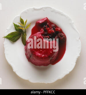 Fruit d'été gelée au lait avec sauce rouge. Banque D'Images