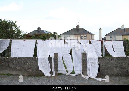 Draps de l'hôtel avec le nom de centaines d'enfants décédés drapés sur les portes d'un lieu de sépulture d'une masse à Tuam, Co Galway où une veillée aura lieu lors de la visite du pape à Knock Shrine à Mayo. Banque D'Images