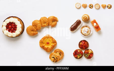 Sélection de gâteaux et pâtisseries, y compris le gâteau crème de fraise, croissants, danoises, tartelettes, fruits, muffins, eclair au chocolat Vue de dessus Banque D'Images