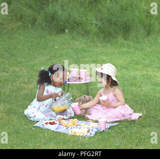 Le pique-nique des oursons en peluche, deux filles assis ensemble sur une couverture à carreaux Banque D'Images