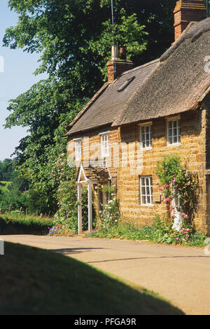 La Grande-Bretagne, l'Angleterre, l'Oxfordshire, nr Banbury, chaumière sur la route de campagne tranquille, façade, vue de côté. Banque D'Images