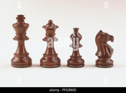 En bois brun foncé, quatre pièces des échecs, Roi, Reine, chevalier, l'évêque. Banque D'Images