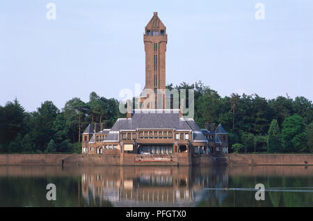 Holland, Jachthuis St Hubertus, Pavillon de chasse construit en 1920 par HP Berlage, avec de l'eau au premier plan. Banque D'Images