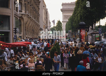 France, Paris, Avenue des Champs Elysées, avec l'Arc de Triomphe masquée derrière les arbres, l'engorgement des scène de rue. Banque D'Images