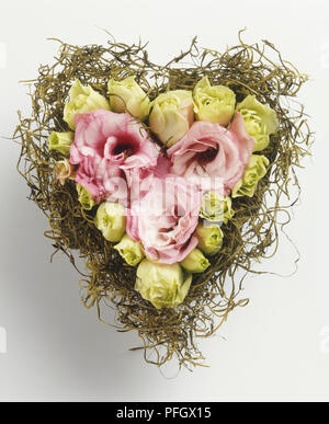 Roses disposés dans un panier en forme de cœur Banque D'Images
