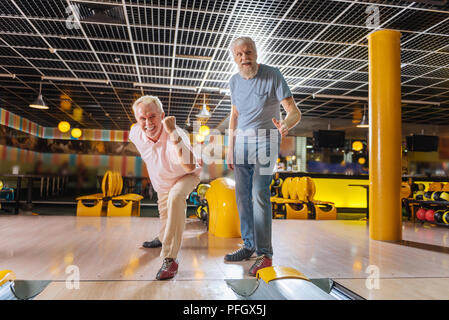 Nice positif des hommes âgés se sentir heureux dans le bowling club Banque D'Images