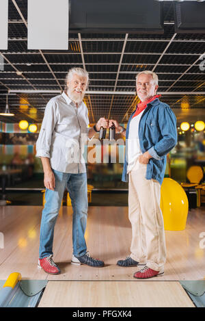 Ravi belle d'hommes occupant des bouteilles de bière Banque D'Images