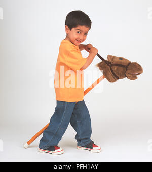 Boy holding bridle de Dada à côté de lui. Banque D'Images