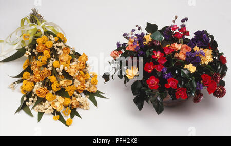 Deux bouquets de roses séchées affiche, un bouquet avec Batchelors, boutons de fleurs éternelles, et d'Eucalyptus avec ruban de satin jaune et blanc, et un arrangement de roses multicolores avec barbeaux et glycerind feuilles de lierre dans un pot. Banque D'Images