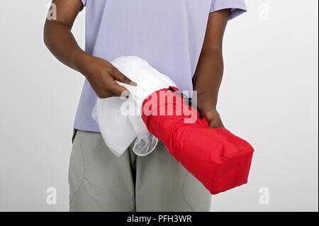 Jeune femme prenant moustiquaire en sac Banque D'Images