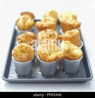 Yorkshire pudding, cuits dans des moules neuf dariole, sur une plaque à pâtisserie Banque D'Images