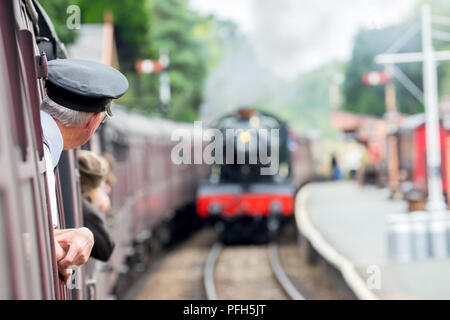 Vue arrière du contrôleur (pris à bord) vintage de transport en tant que station de train s'approche. Deuxième machine à vapeur s'approche. Banque D'Images