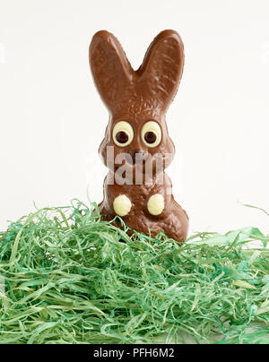 Lapin chocolat derrière faux gazon Banque D'Images