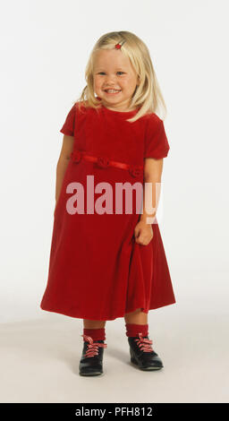 Smiling blonde dans une robe rouge, front view Banque D'Images