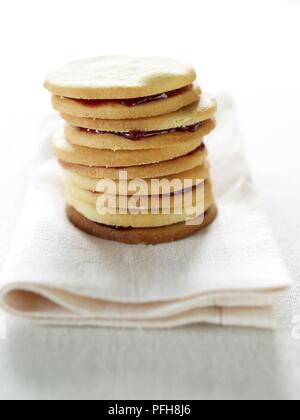 Pile de sables, framboise biscuits français traditionnellement rempli de confiture de framboises, sur une serviette pliée, close-up Banque D'Images