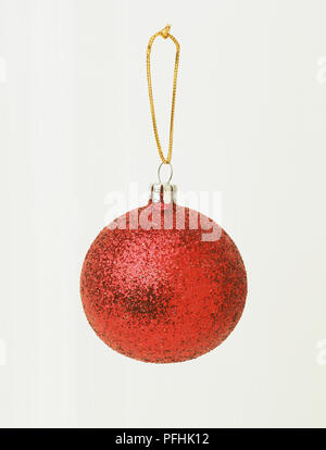 Cuir babiole rouge sur la chaîne d'or, vue de face. Banque D'Images