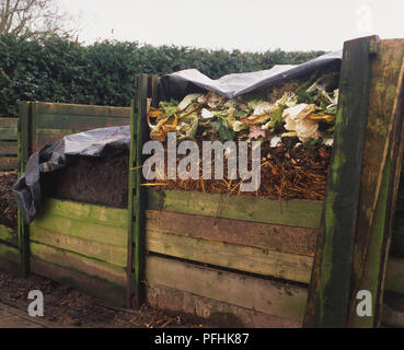 Grand bac à compost en bois dans jardin, vue de côté. Banque D'Images