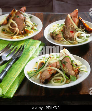 Canard poêlé servi sur assiette avec la salade de mangue et papaye verte Banque D'Images