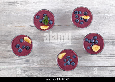 Smoothie délicieux avec des bleuets, des graines de chia et de la banane dans les verres sur la table en bois, vue du dessus Banque D'Images