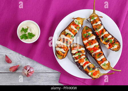 Aubergines au four délicieux farci au quinoa, champignons, tomates et sauce Tahini arrosé sur, sain et facile recette méditerranéenne sésame,vegan Banque D'Images