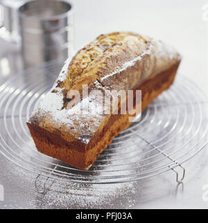 Gâteau de pain saupoudrés de sucre glace sur une grille de refroidissement, high angle view Banque D'Images