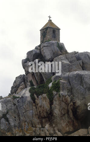 France, Bretagne, Cote de Granit Rose, plage de Port Blanc, chapelle au sommet d'une falaise rocheuse Banque D'Images