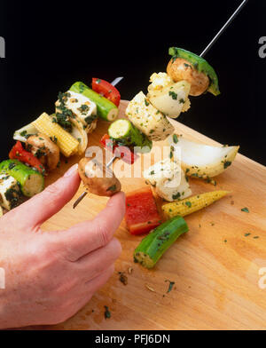 Les légumes d'être enfilées sur des brochettes de métal, Close up. Banque D'Images