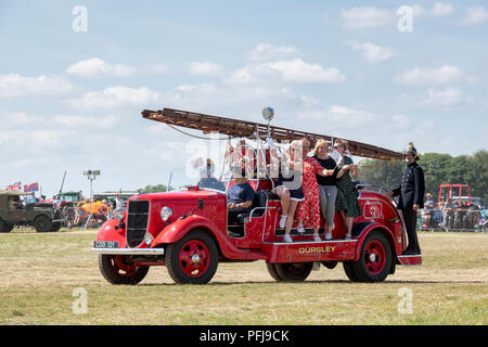 Vintage fire engine transportant un groupe de danseuses lors d'une foire à vapeur en Angleterre Banque D'Images