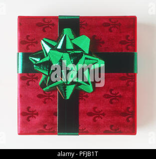 Gift wrapped en rouge fleur de lys et papier motif arc vert Banque D'Images