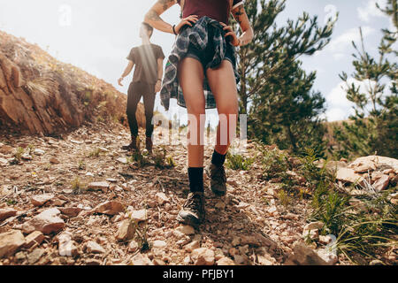 Explorer en train de marcher dans une forêt. Femme marche sur un sentier rocheux avec sa partenaire après son sur une journée ensoleillée. Banque D'Images