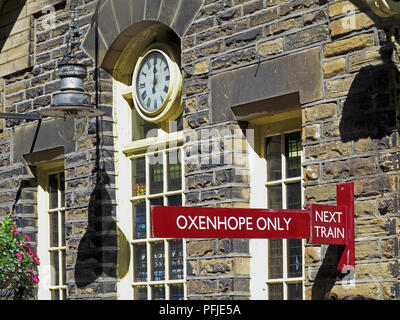 À Haworth Station sur la ligne, KWVR avec le prochain train, signé à l'horloge arrêtée Oxenhope et montrant midi Banque D'Images