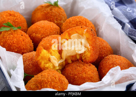 L'italien arancini - safran boulettes de riz farcies au fromage dans le plat de cuisson, vue de dessus, close-up Banque D'Images