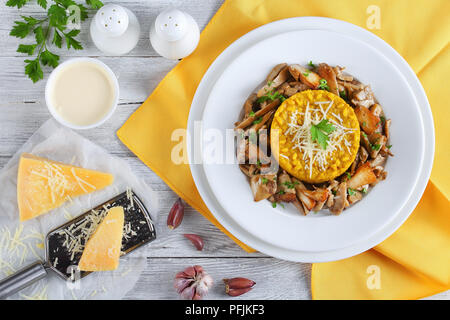 Safran délicieux risotto crémeux aux cèpes frits garnis de saupoudrée de persil et de parmesan râpé servi sur des assiettes blanches à la crème, Banque D'Images