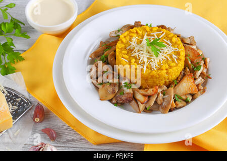 Safran délicieux risotto crémeux aux cèpes bio poêlée de persil et de parmesan râpé servi sur des assiettes blanches à la crème, classic i Banque D'Images