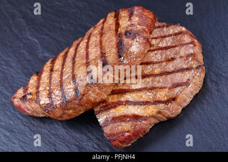 Close-up of sex de délicieux steaks de boeuf au barbecue avec des rayures sur la plaque en ardoise noire, côté Vue du dessus Banque D'Images