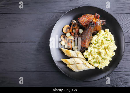 Une partie de la cuisine française classique et le ragoût de coq servi sur la plaque noire avec purée de pommes de terre et le pain, vue horizontale d'en haut Banque D'Images