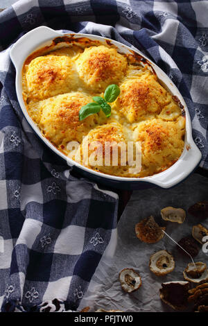 La polenta de pommes de terre farcies aux champignons boulettes végétariennes et un ragoût cuit dans un four avec de la crème, fromage et sauce panais dans le plat de cuisson. cèpes séchés Banque D'Images