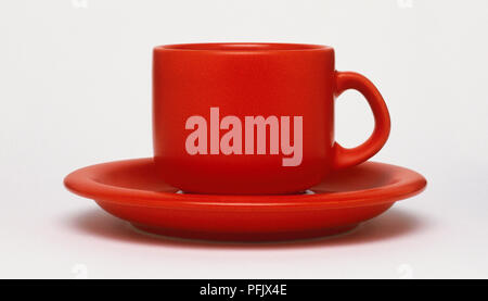 Tasse à café rouge sur la correspondance avec soucoupe Banque D'Images