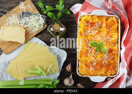 Lasagne italienne classique en couches avec un ragoût à la bolognaise, garni de fromage fondu et de feuilles de basilic frais dans le plat de cuisson. Ingrédients pour la lasagne au bac Banque D'Images