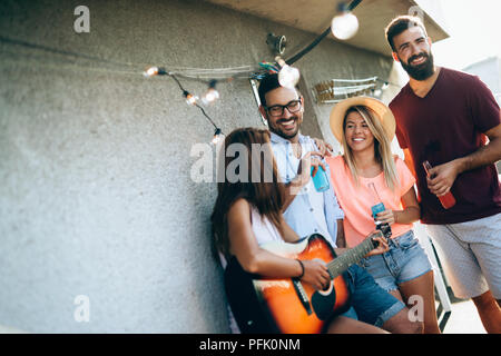 Groupe d'happy friends having party sur le toit Banque D'Images